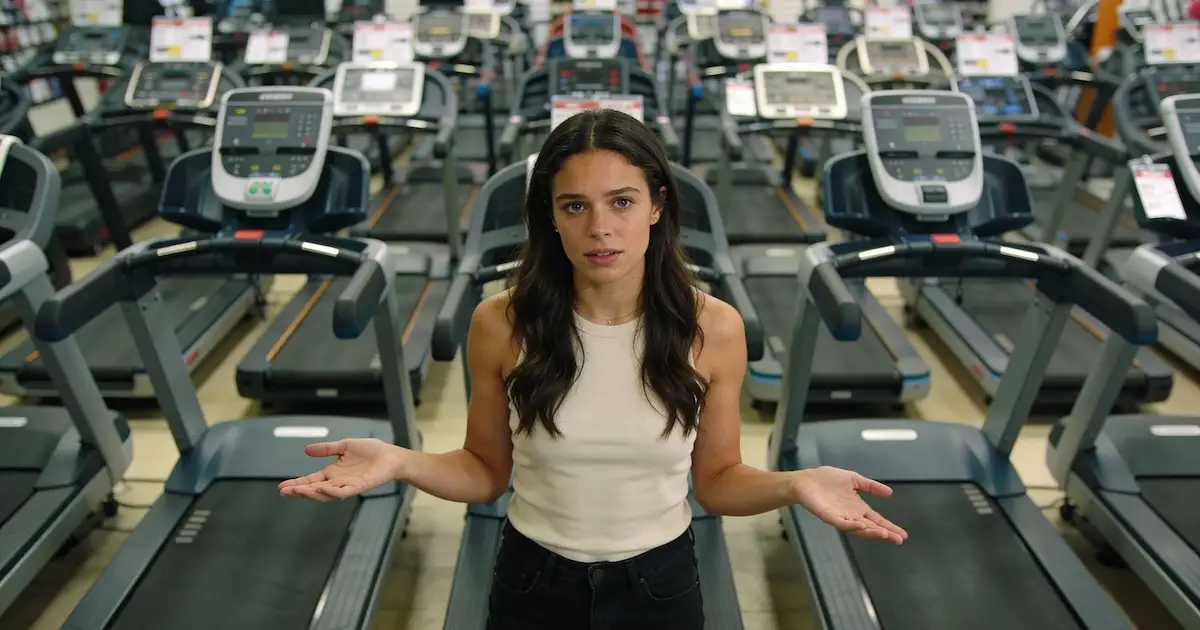 Young woman in front of dozens of treadmills